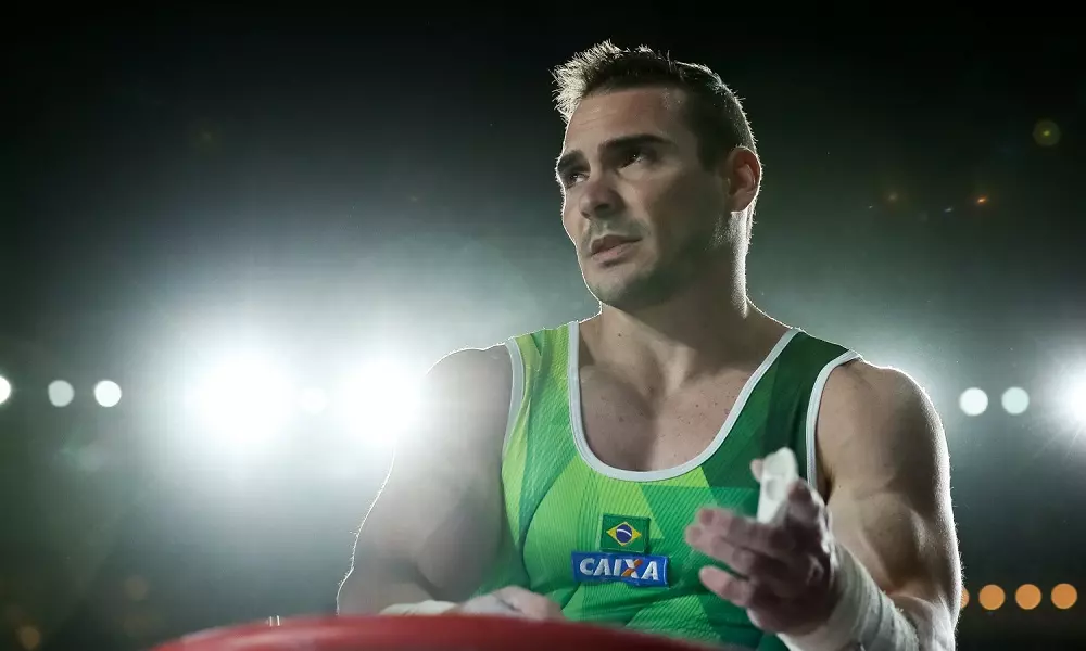 Arthur Zanetti passa magnésio nas mãos para disputar argolas em competição de ginástica Artística