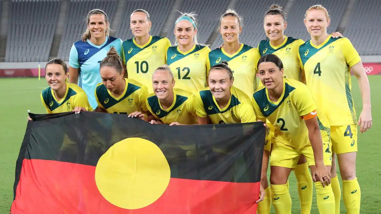 Seleção de futebol feminino da Austrália segura a bandeira aborígene