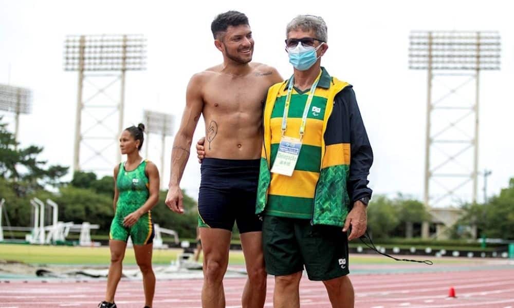 Petrúcio Ferreira e o técnico Pedrinho Almeida caminham abraçados pela pista de treinamento em Hamamatsu