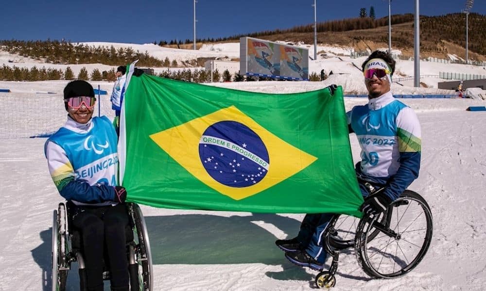 Aline e Cristian ostentam bandeira brasileira pequim-2022 jogos paralímpicos de inverno