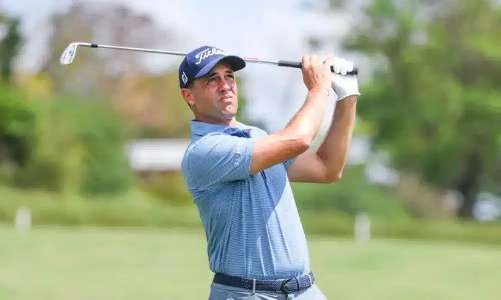 Alexandre Rocha, atleta de golfe, após dar tacada em uma competição. Ao seu fundo, um gramado verde. Simmons Bank Open Golfe 2022