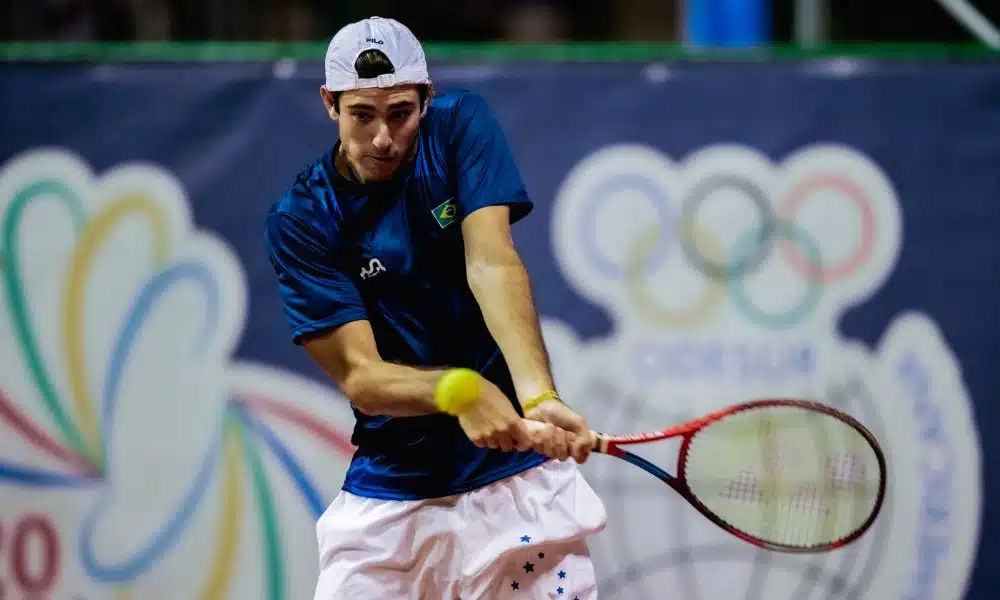 Gustavo Heide rebate a bola com um forehand usando duas mãos