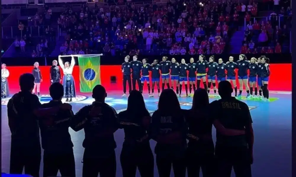 Equipe do Brasil, antes do jogo com a Dinamarca, enfileiradas para o hino nacional. Na frente da image, a comissão técnica de costas