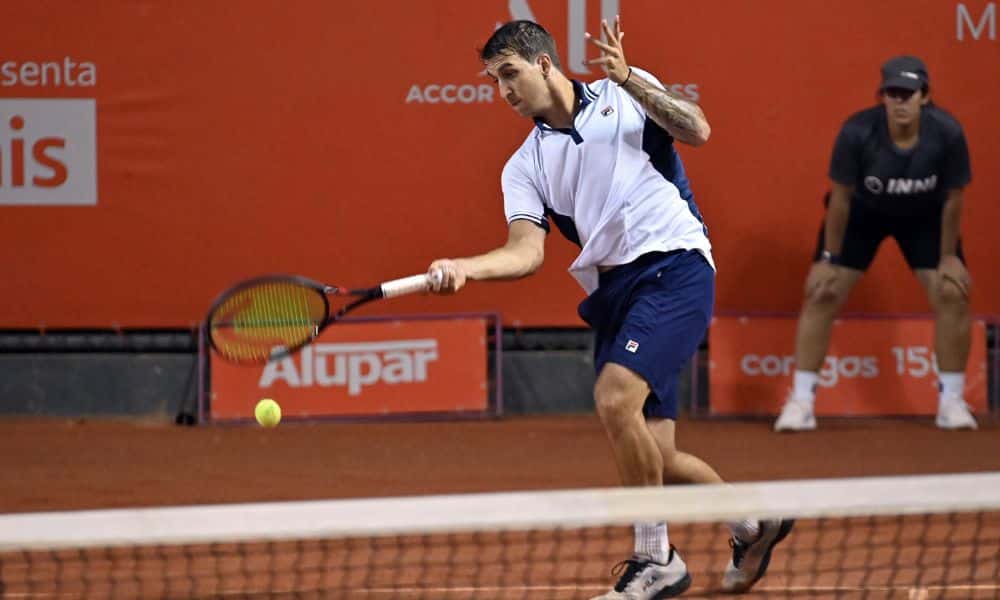 Felipe Meligeni Alves ataca bola com um forehand de direita. Ele veste bermuda azul e camisa branca