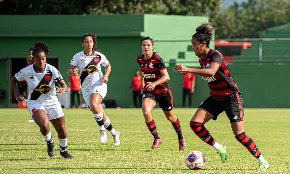 Duda, do Flamengo, corre com a bola cercada por duas vascaínas