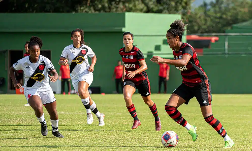 Duda, do Flamengo, corre com a bola cercada por duas vascaínas