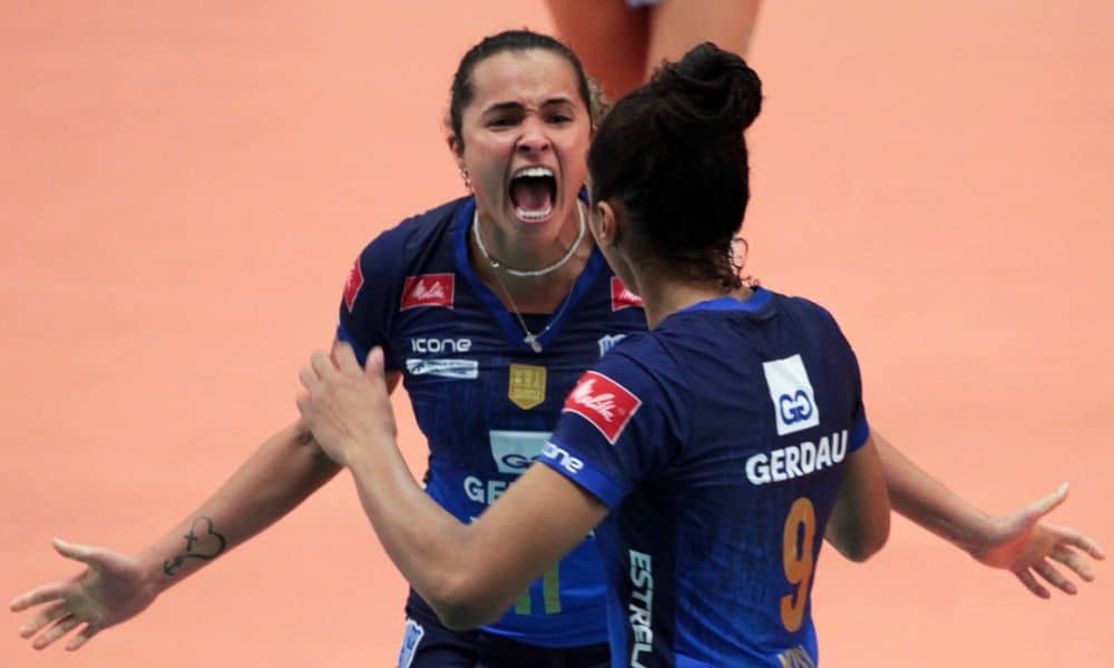 Mineiro de vôlei Praia Clube - Duas Jogadoras do Minas, contra o Brasília, se abraçam após um ponto. Elas vestem o uniforme azul (em degradê) da equipe