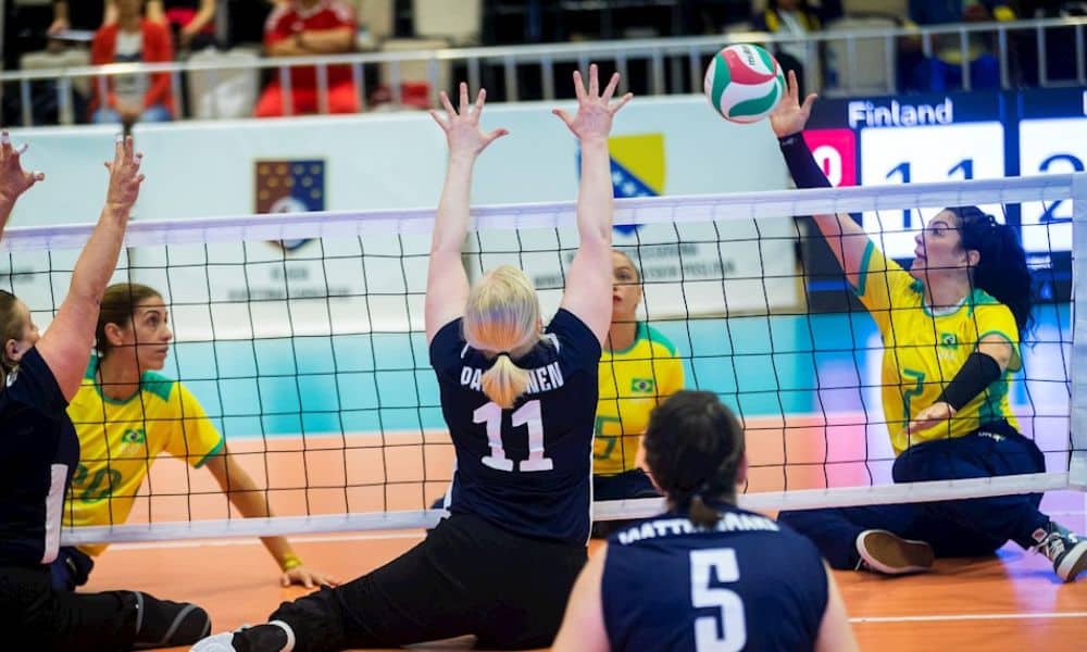 Mundial de vôlei sentado: Jogadora do Brasil ataca a bola, enquanto finlandesa tenta bloquear a jogada