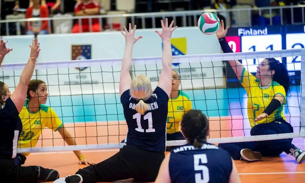 Mundial de vôlei sentado: Jogadora do Brasil ataca a bola, enquanto finlandesa tenta bloquear a jogada