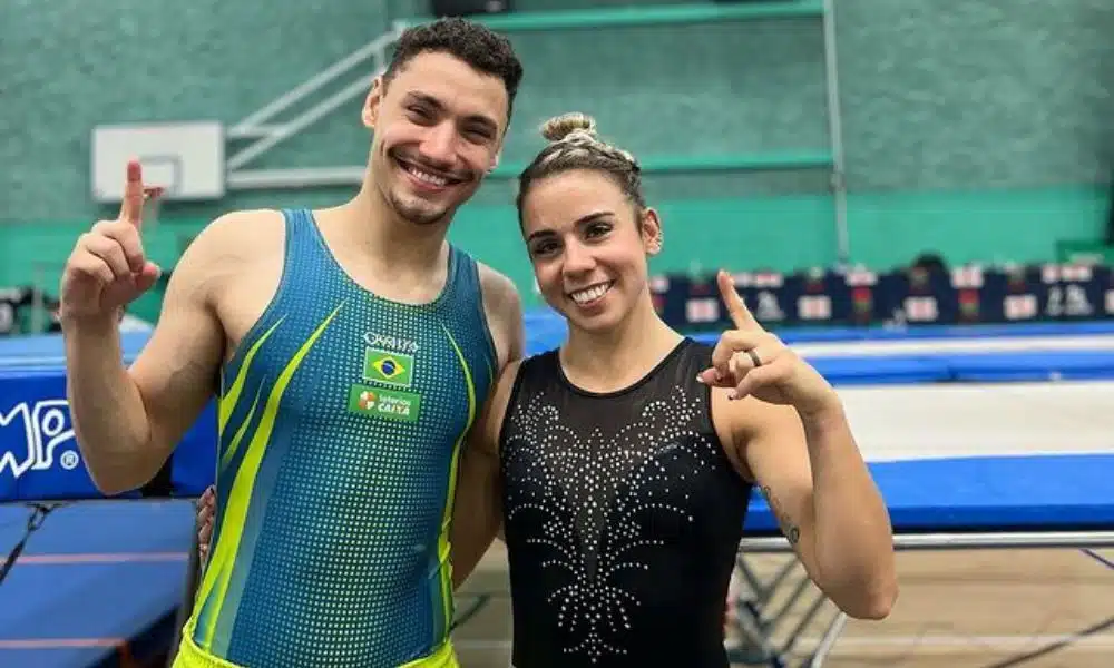 Rayan e Camila posam para foto fazendo o número 1 com o dedo