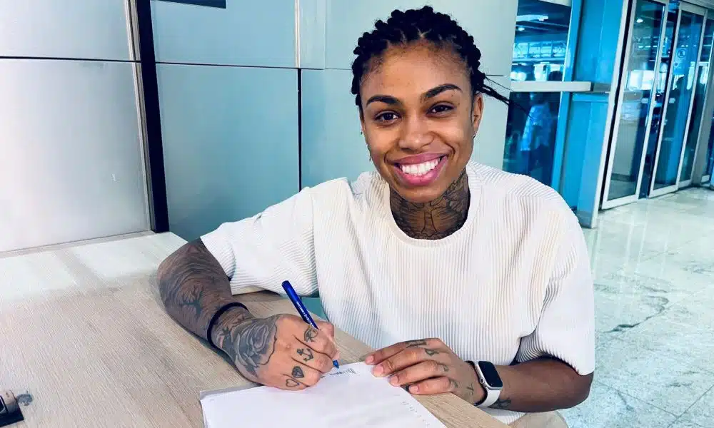 Bruna de Paula posa para foto enquanto assina o contrato do novo clube