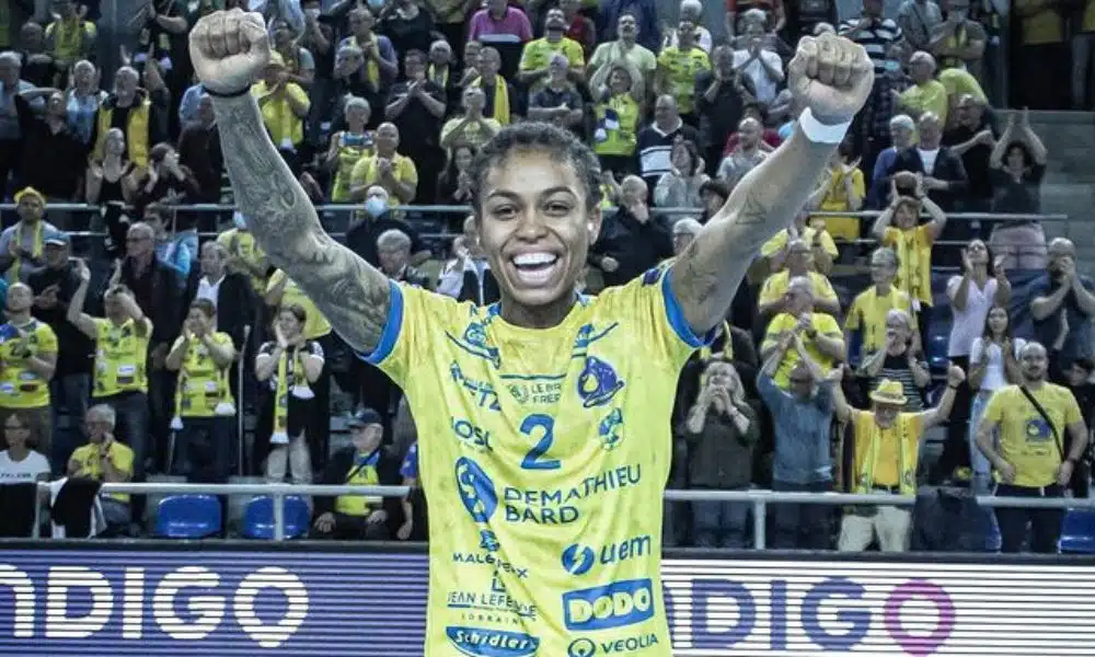 Bruna de Paula ergue os braços pra comemorar vitória do Metz na Champions League de handebol