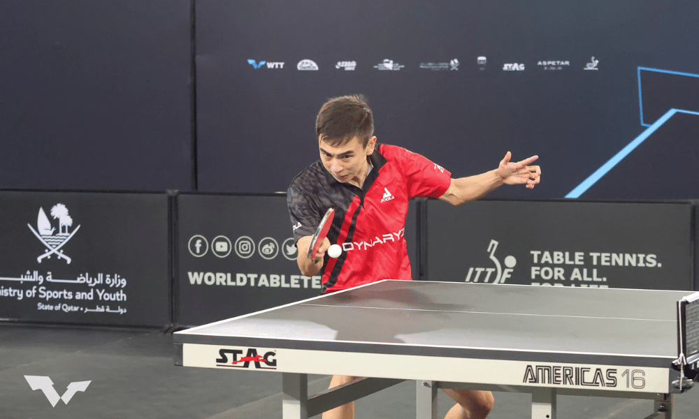 Vitor Ishiy, de vermelho, ataca bolinha com a raquete, no WTT Feeder de Dusseldorf