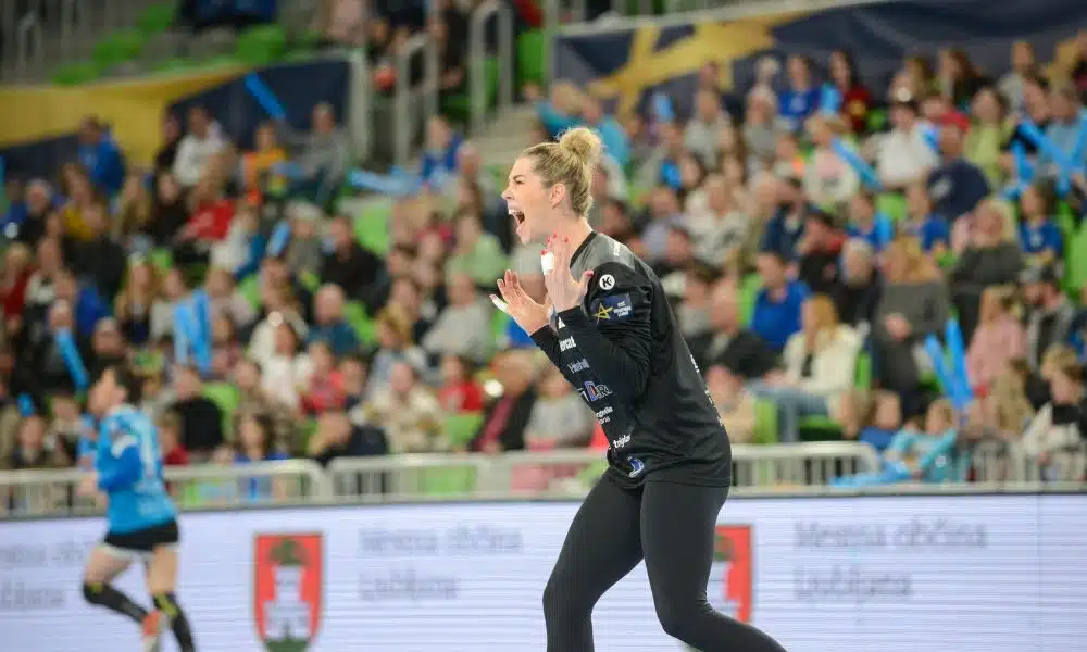 mas Babi grita para comemorar defesa na Champions League de handebol feminino. Ela veste uniforme todo preto do Krim Mercator