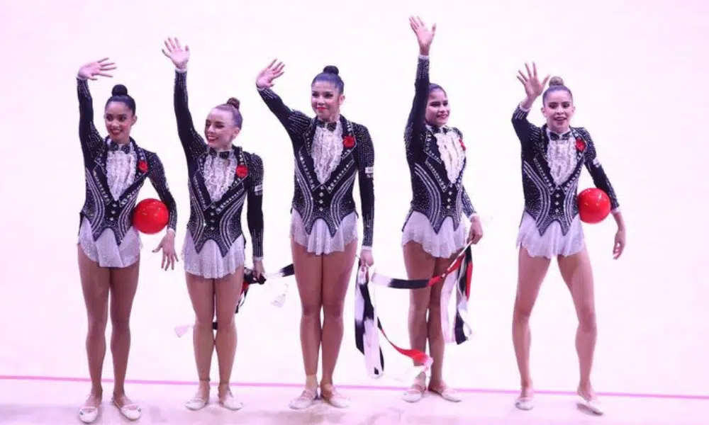 Mas - conjunto do Brasil de fita e bola. Atletas vestem um uniforme estilo black-tie