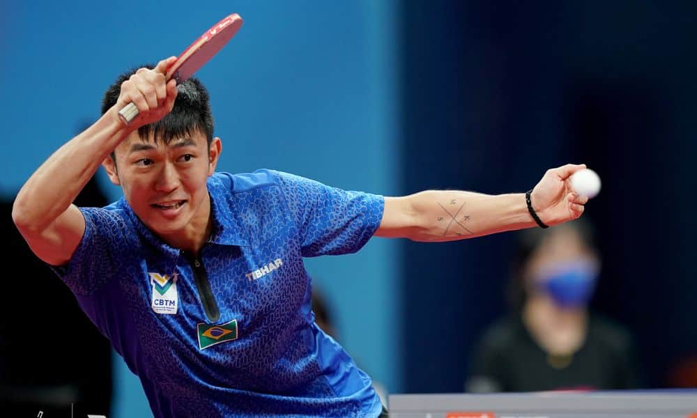 mas - Eric Jouti olha para a bola antes de atacá-la no WTT Feeder de Antalya. Ele veste uniforme todo azul durante o WTT Contender de Tunis; com Vitor Ishiy no tênis de mesa