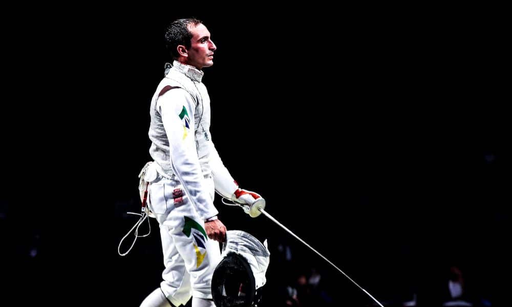Guilherme Toldo tira o capacete enquanto segura sua arma no Grand prix de florete