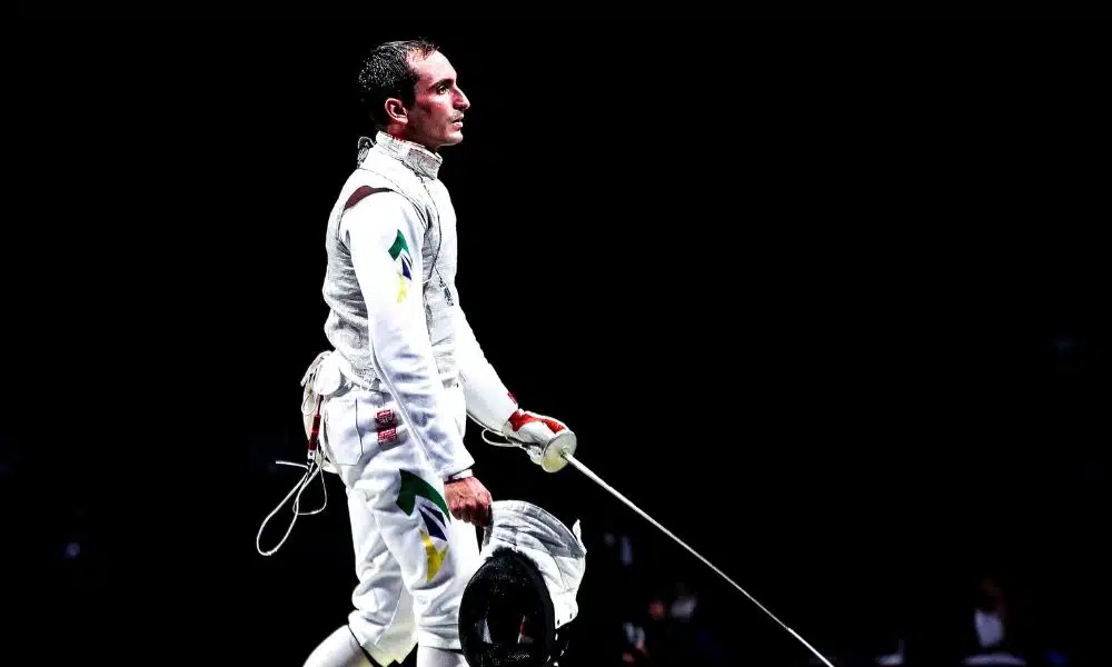 Guilherme Toldo tira o capacete enquanto segura sua arma no Grand prix de florete