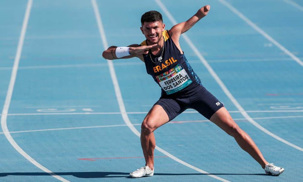 Mas - Petrúcio Ferreira veste um uniforme azul marinho do Brasil. Eles faz o gesto de raio para a foto mas
