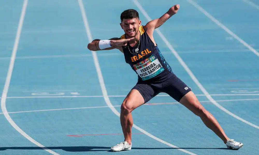 Mas - Petrúcio Ferreira veste um uniforme azul marinho do Brasil. Eles faz o gesto de raio para a foto mas