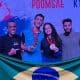 No centro da imagem, Adriano dos Santos e Melyssa Resende seguram medalhas do Aberto Dominicano Júnior de taekwondo