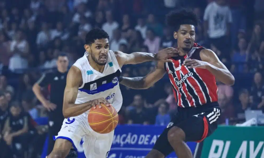 Jogador do Pinheiros conduz bola enquanto afasta aleta do São Paulo com o braço. NBB Jogo 2 (Ricardo Bufolin/ECP)