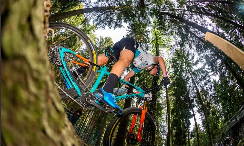 Na imagem, Giuliana Morgen correndo de bicicleta em meio à floresta.