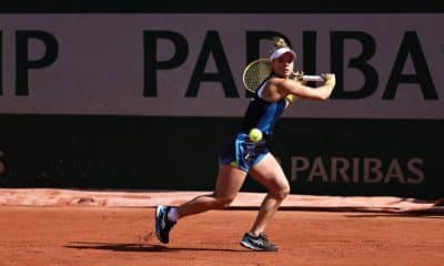 Na imagem, Laura Pigossi rebatendo a bolinha com sua raquete, em um golpe de backhand.