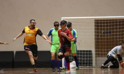 Samir corre em direção ao centro da quadra enquanto o chamador Taffarel corre em sua direção para comemorar o gol da Apadv. Ao fundo, goleiro da Acergs está se levantando / Regional Sul-Sudeste de Futebol de Cegos