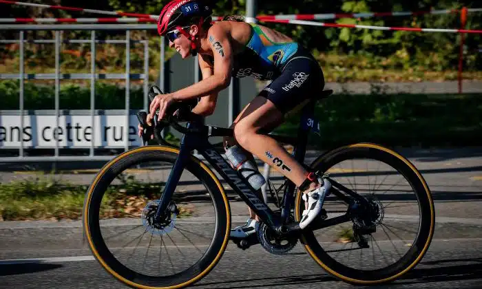 Na imagem, Vittoria Lopes de lado, pedalando em cima da bicicleta.