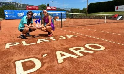 Carol Meligeni Alves posa para foto segurando o troféu da competição ao lado de seu treinador