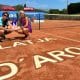Carol Meligeni Alves posa para foto segurando o troféu da competição ao lado de seu treinador