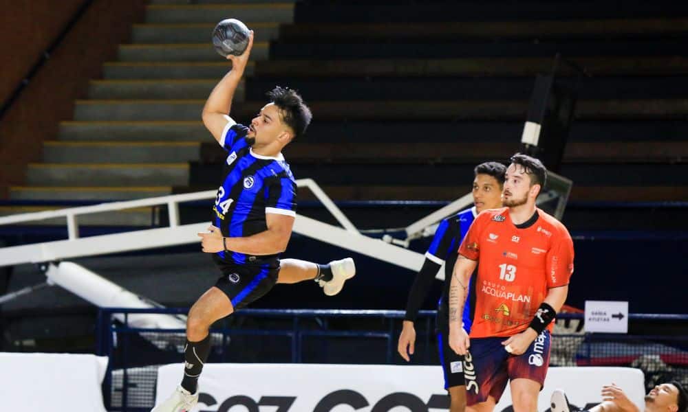 Atleta do Pinheiros passa por jogador do Itajaí e arremessa bola ao gol no Sul-Centro Americano de handebol