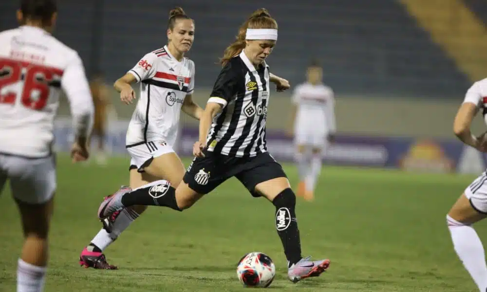 Jogadora do Santos passa a bola para companheira em jogo contra o São Paulo no Paulistão Feminino