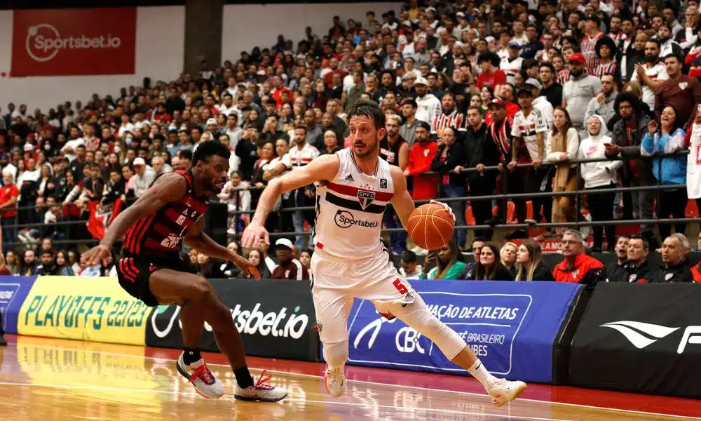 Elinho, do São Paulo, conduz a bola marcado por atleta do Flamengo em jogo do NBB