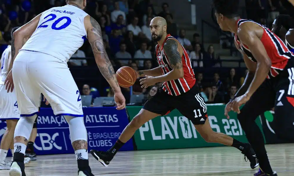 Marquinhos, do São Paulo, conduz a bola enquanto é marcado por jogador do Pinheiros em partida do NBB