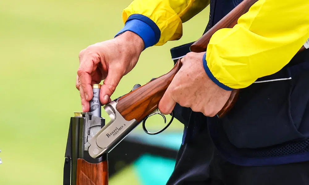 Foto de atirador colocando munição na arma - Leonardo Lustoza, Artur Fortunato e Emanuel Munaretto na fossa olímpica da Copa do Mundo de tiro esportivo