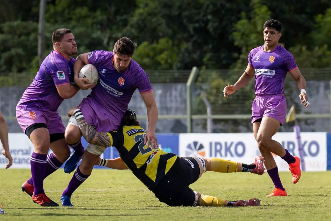 Atleta dos Cobras carrega a bola enquanto jogador do Peñarol tenta Tackleá-lo em jogo do Super Rugby Américas