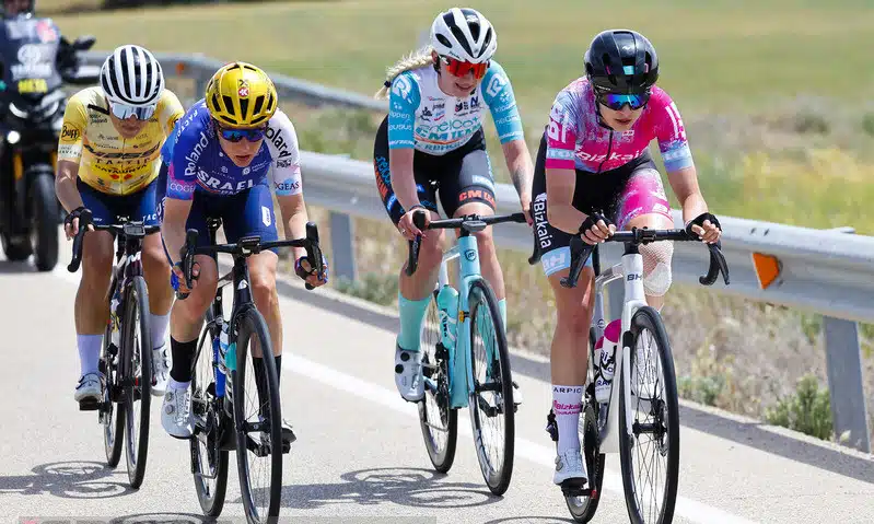 Na imagem, Ana Vitória Magalhães, com a roupa rosa, pedalando com mais três ciclistas a sua direita.
