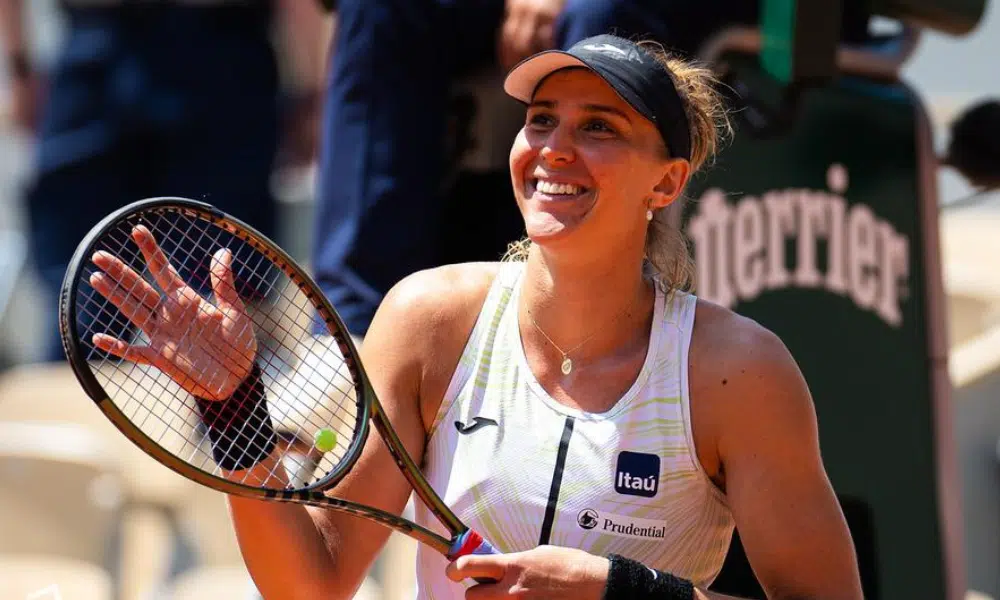 Bia Haddad sorri enquanto segura a raquete em Roland Garros