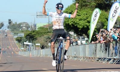 Na imagem, Caio Godoy comemorando em cima de sua bicicleta na linha de chegada.