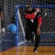 Denis completa o giro com o braço direito no arremesso enquanto bola quica à sua frente na quadra; ao fundo, árbitra de linha observa (Foto: Renan Cacioli/ CBDV)