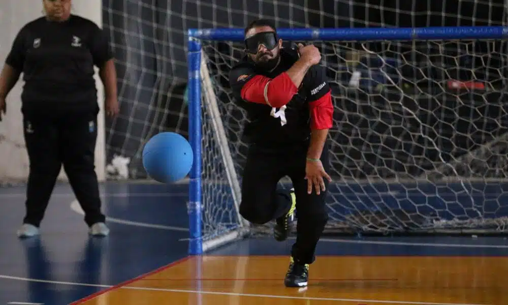 Denis completa o giro com o braço direito no arremesso enquanto bola quica à sua frente na quadra; ao fundo, árbitra de linha observa (Foto: Renan Cacioli/ CBDV)