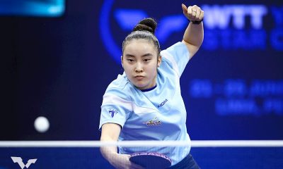 Na imagem, Laura Watanabe com sua raquete, acertando a bolinha.