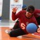 Marco Antônio faz defesa em jogo do Regional Sudeste 2 de goalball. Ele é um jovem negro, veste calça preta e camisa portô e se estica para alcançar a bola