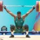 Marco Túlio Gregório carrega o halter com os pesos sobre sua cabeça. Ele competiu no Grand Prix de Havana em Cuba
