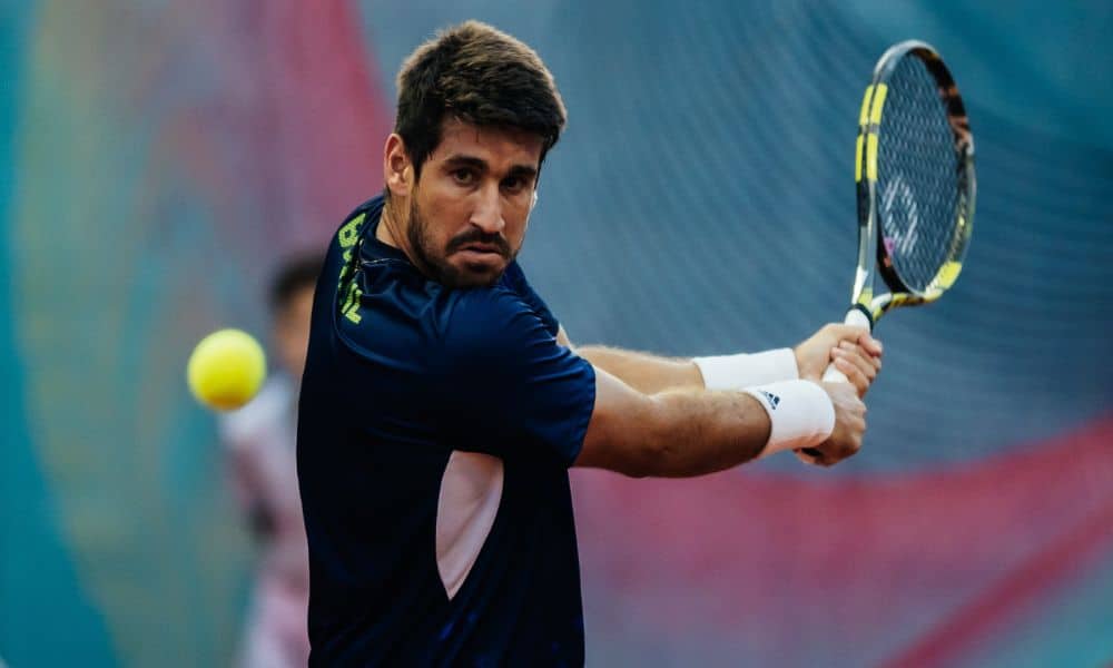 Orlando Luz olha para a bola antes de golpeá-la com um backhand usando as duas mãos. Ele está na final do Challenger de Cali