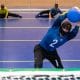 Atletas da seleção masculina de goalball em um treino em São Paulo. No primeiro plano, um jogador segura a bola, enquanto ao fundo, dois atletas estão deitados em posição de defesa