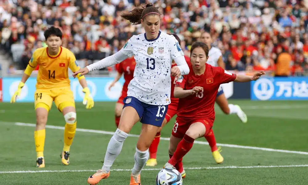 Alex Morgan, dos Estados Unidos, está com a bola enquanto jogadora do Vietnã tenta roubá-la