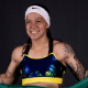Bia Ferreira sorridente enquanto segura bandeira do Brasil na luta do boxe profissional